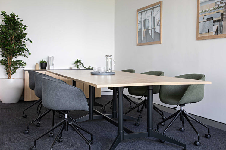 Boardroom table and upholstered chairs in a furnished meeting space