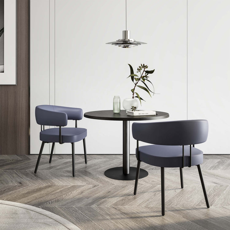 Upholstered chairs around a round table in a furnished breakout setting
